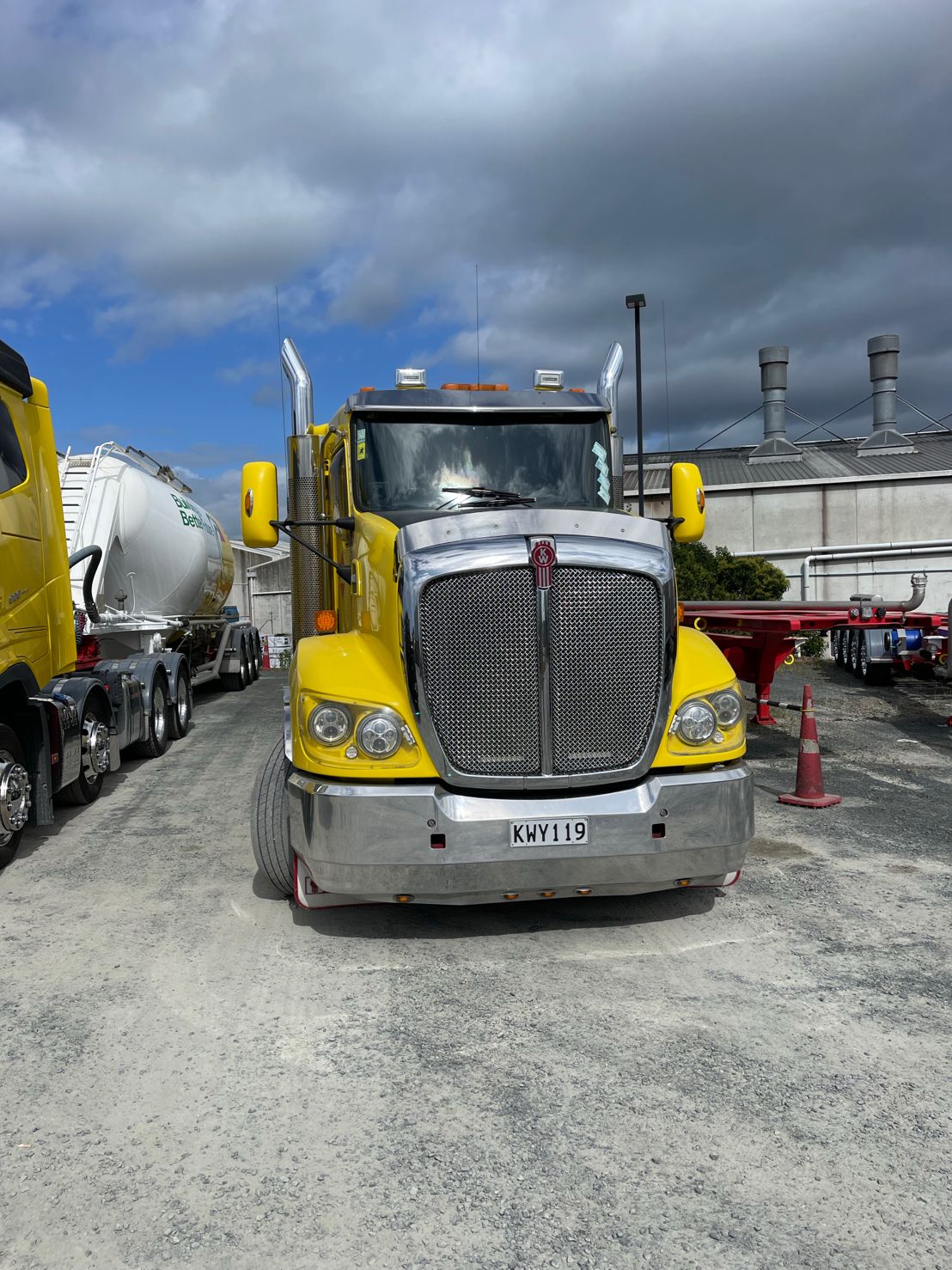 Yellow Kenworth truck with GPS tracking installation at industrial site